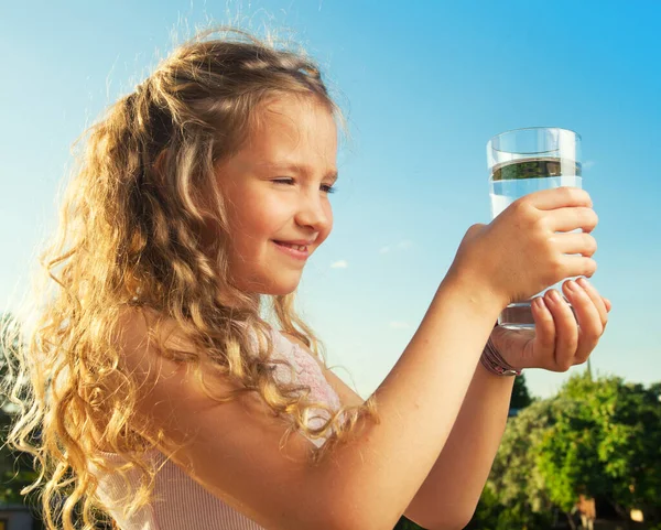 Bambino che tiene acqua di vetro — Foto Stock