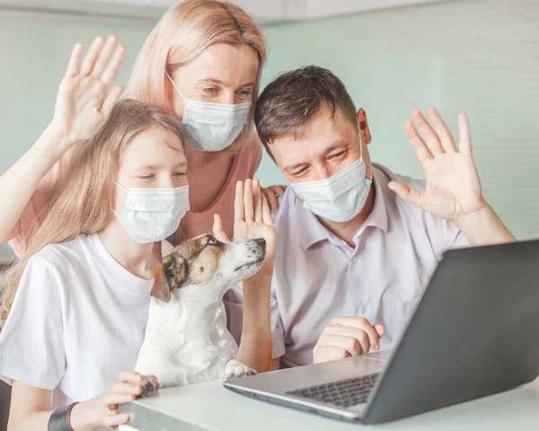 Glückliche Familie sucht Laptop zu Hause in Maske während der Coronavirus-Pandemie — Stockfoto
