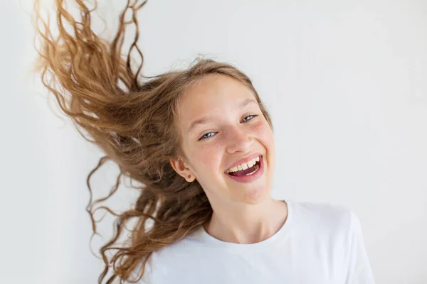 Portret lachende jonge meisje tiener met vliegende krullend haar — Stockfoto