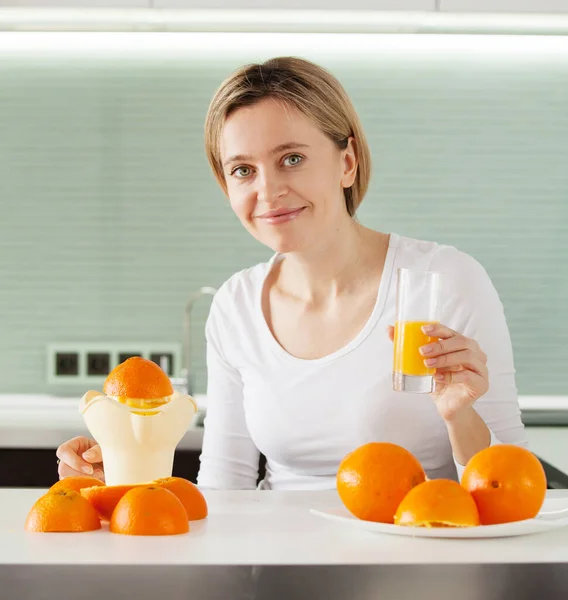 Adult woman cooking orange juice on juicer