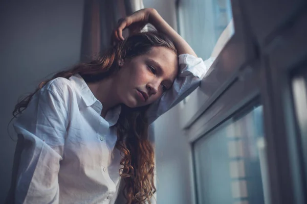 Triste adolescente perto da janela — Fotografia de Stock