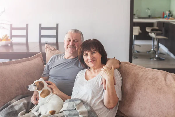 Glada äldre par sitter på soffan hemma — Stockfoto