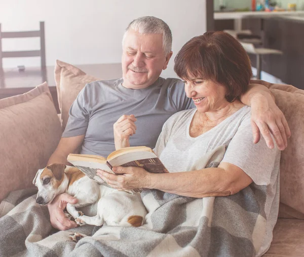 Glada äldre par sitter på soffan hemma — Stockfoto