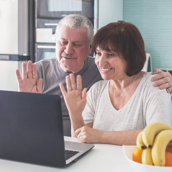 Ouderen paar op zoek naar computer in de keuken — Stockfoto