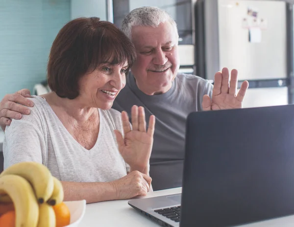 Coppia anziana che guarda il computer in cucina — Foto Stock