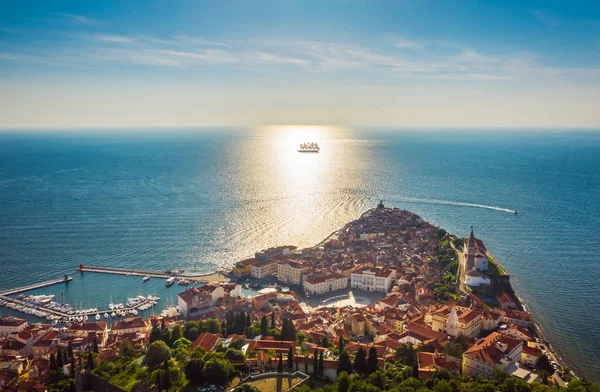 Vista aérea da cidade velha Piran e belo navio à vela com cinco mastros ao pôr do sol . Imagens De Bancos De Imagens