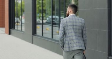 Genç yakışıklı işadamı öğrenci bir takım, istasyonunda Havaalanı veya iş merkezi bir evrak çantası ile birlikte gelir. Arkadan Görünüş