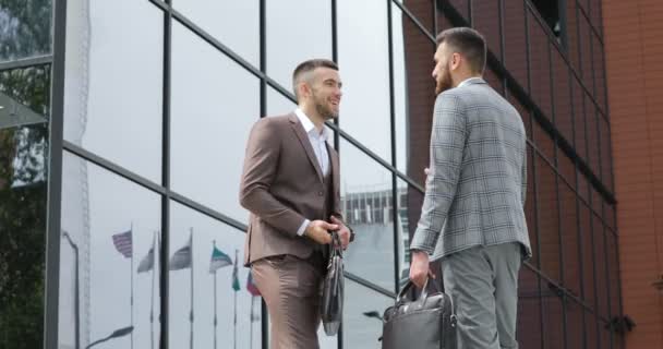 Business partners handshaking. Twee jonge ondernemers, die zijn oude bekenden, ontmoeten en handen schudden — Stockvideo