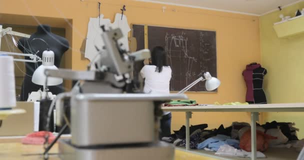 Mujer en el trabajo como diseñadora de moda y sastre, mirando bocetos en atelier — Vídeos de Stock