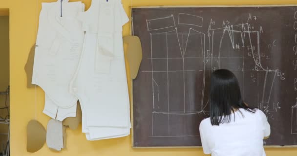 Attraktive junge Modedesignerin arbeitet im Atelier — Stockvideo