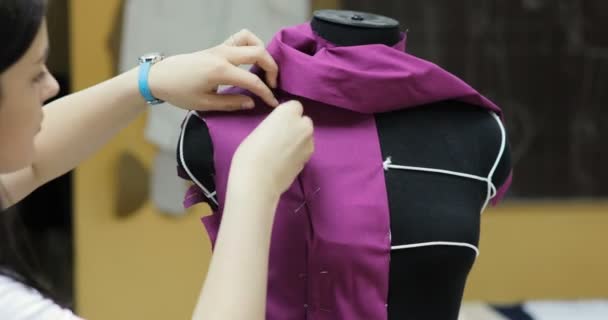 Jonge mode-ontwerper en kleermaker naaister aan te passen van kleding op spastische mannequin en in de studio — Stockvideo