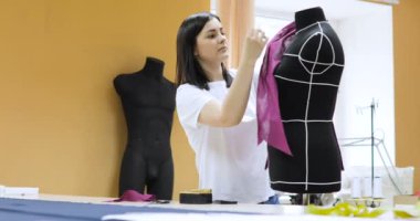 Genç kadın moda tasarımcısı Studio içinde çalışır. Giyim Tasarımcısı ölçümleri mankenler ile çalışma
