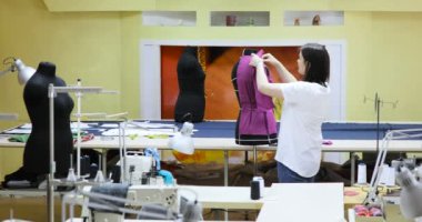 Genç kadın moda tasarımcısı Studio içinde çalışır. Giyim Tasarımcısı ölçümleri mankenler ile çalışma
