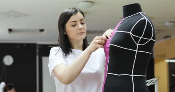 Joven diseñador de moda, sastre y modista ajustando la ropa en el maniquí de sastrería y en el estudio — Vídeo de stock