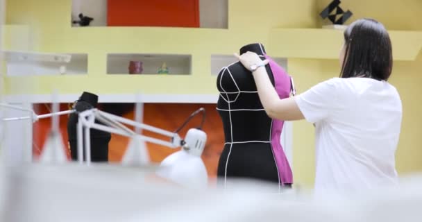 Jonge mode-ontwerper en kleermaker naaister aan te passen van kleding op spastische mannequin en in de studio — Stockvideo