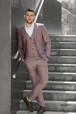 Akıllıca giyinen işadamı, Modern iş adamı. Arka planda bina ile tam takım açık havada duran kendine güvenen genç adam