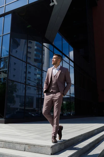 Akıllıca giyinen işadamı, Modern iş adamı. Arka planda bina ile tam takım açık havada duran kendine güvenen genç adam