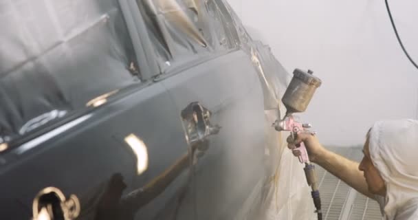 Filmagem de um carro sendo pintado e envernizado em uma câmara de pintura Lacando um carro preto — Vídeo de Stock