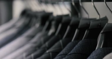 Erkek takım elbise ceket askı üzerinde satır. Askı bir mağazada asılı yeni güzel giysi koleksiyonu.