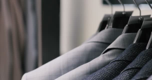 Mens suit at tailors shop. Mens hands choose a jacket in their wardrobe. Male choosing — Stock Video