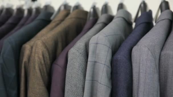 Mens passen bij kleermakers shop. Mens handen Kies een jas in hun garderobe. Mannelijke kiezen — Stockvideo