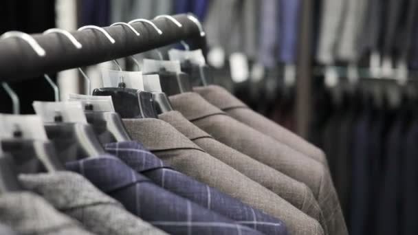 Traje de hombre en sastrería. Las manos de hombre eligen una chaqueta en su armario. Elegir masculino — Vídeos de Stock