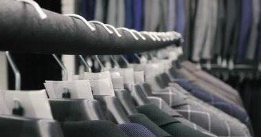 Erkek takım elbise ceket askı üzerinde satır. Askı bir mağazada asılı yeni güzel giysi koleksiyonu