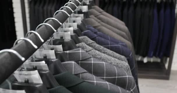 Мужской костюм в магазине портных. Мужские руки выбирают куртку в своем гардеробе. Мужской выбор — стоковое видео
