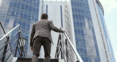 İş Merkezi için merdiven çıkma bir genç yakışıklı işadamı