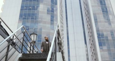 Akıllı telefon adam şehirde cep telefonunda arıyor. Yakışıklı genç iş adamı mutlu giyen takım elbise ceket açık havada gülümseyen Smartphone'da konuşuyor.