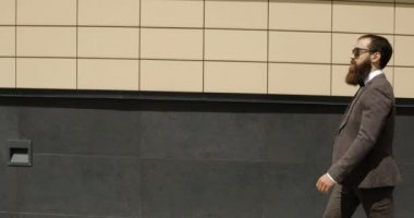 Bina ve etrafa büyük ofisinin dışında yürüyüş mutlu çekici beyaz iş adamı. Memnun ve mutlu görünen adam.