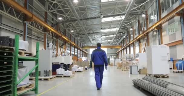Siga las imágenes del trabajador de la fábrica que camina a través de instalaciones industriales . — Vídeo de stock