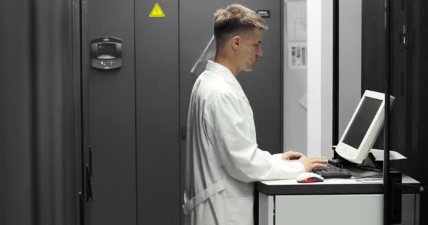 Técnico de TI Trabalha em um computador em Big Data Center cheio de servidores Rack. Ele executa diagnósticos e manutenção Stets up System . — Vídeo de Stock