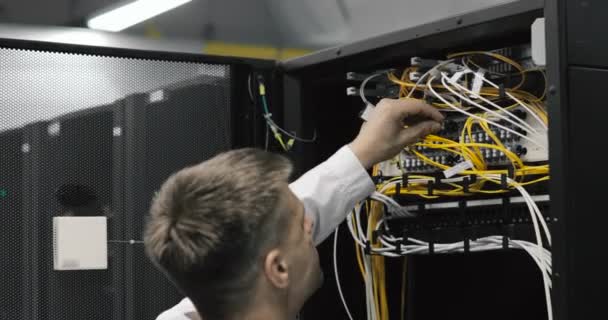 Homme ingénieur serveur marche à travers le centre de données de travail plein de serveurs rack — Video