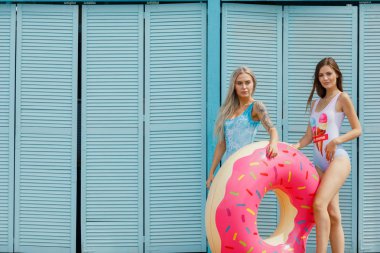 İki mutlu kız deniz üzerinde bekletin. mutlu kız sahilde. şişme yüzme ile güzel kız çörek şeklinde halka