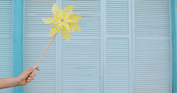 Yellow windmill spinning in wind on blue deck background. summer concept — Stock Video