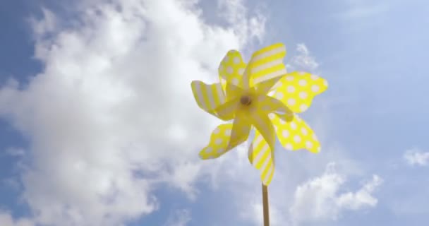 Žlutá větrný mlýn spinning ve větru na modré obloze. letní koncept — Stock video