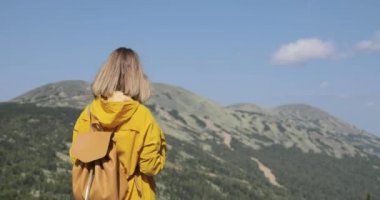 Dağ tepe üzerinde manzarayı sırt çantası ile yenilikçi genç kız