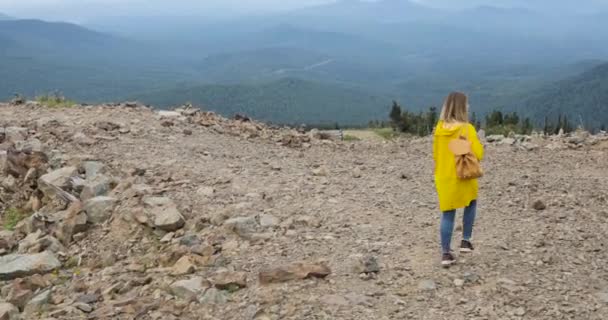 Senderismo activo saludable hipster en impermeable amarillo en las montañas — Vídeo de stock