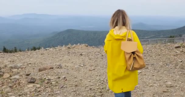 Senderismo activo saludable hipster en impermeable amarillo en las montañas — Vídeos de Stock