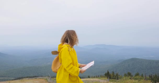 Giovane escursionista donna che guarda la mappa dalla cima della montagna — Video Stock