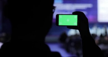 video alma kişi ve fotoğraf üstünde hareket eden smartphone Konferansı'nda. Yeşil ekran dahil luma mat ile. İş insanlar seminer konferans toplantı Office eğitim kavramı