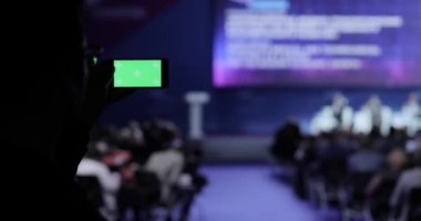 video alma kişi ve fotoğraf üstünde hareket eden smartphone Konferansı'nda. Yeşil ekran dahil luma mat ile. İş insanlar seminer konferans toplantı Office eğitim kavramı