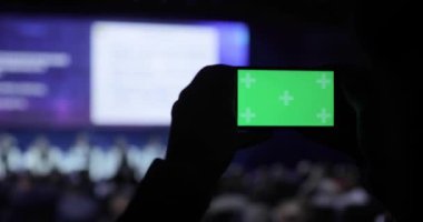 video alma kişi ve fotoğraf üstünde hareket eden smartphone Konferansı'nda. Yeşil ekran dahil luma mat ile. İş insanlar seminer konferans toplantı Office eğitim kavramı