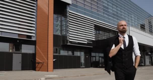 Feliz atractivo hombre de negocios caucásico caminando fuera cerca de gran edificio de oficinas y mirando a su alrededor . — Vídeo de stock