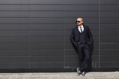 Kendinden emin ve başarılı. Uzaklıkta açık havada arka planda Bina office ile yürürken arıyorum yakışıklı genç işadamı