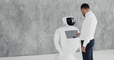 Şık bir adam bir robot ile iletişim kuran robot plastik mekanik bir kol presler el sıkışma. Sibernetik sistem bugün. Modern robotik teknolojiler. Özerk insansı robot.