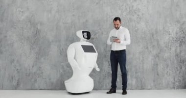 Şık bir adam bir robot ile iletişim kuran robot plastik mekanik bir kol presler el sıkışma. Sibernetik sistem bugün. Modern robotik teknolojiler. Özerk insansı robot.