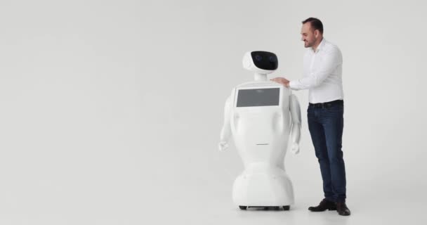 Mann streichelt Roboter. Freundschaft mit einem Roboter. moderne Robotertechnologien. ein Mann kommuniziert mit einem Roboter, — Stockvideo