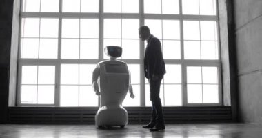 Şık bir adam bir robot ile iletişim kuran robot plastik mekanik bir kol presler el sıkışma. Sibernetik sistem bugün. Modern robotik teknolojiler. Özerk insansı robot.